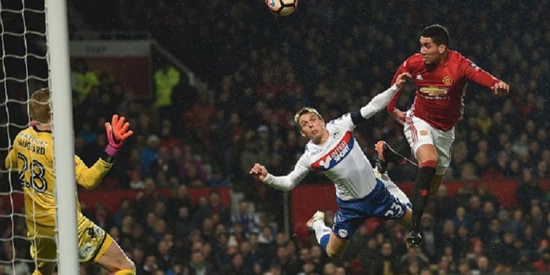 Bek Manchester United, Chris Smalling, mencetak gol via sundulan saat menghadapi Wigan Athletic dalam laga Piala FA di Old Trafford, Minggu (29/1/2017). 