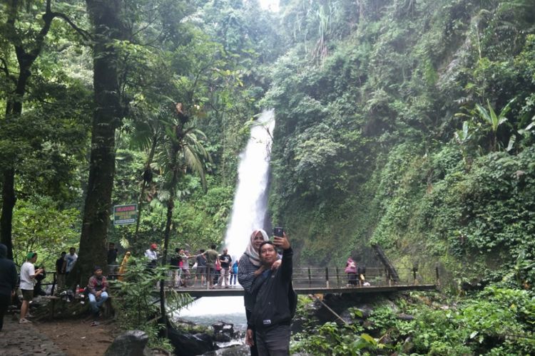 Pengunjung berfoto di dekat Curug Sawer yang terletak di dalam kawasan wisata Situ Gunung, Sukabumi, Jawa Barat.