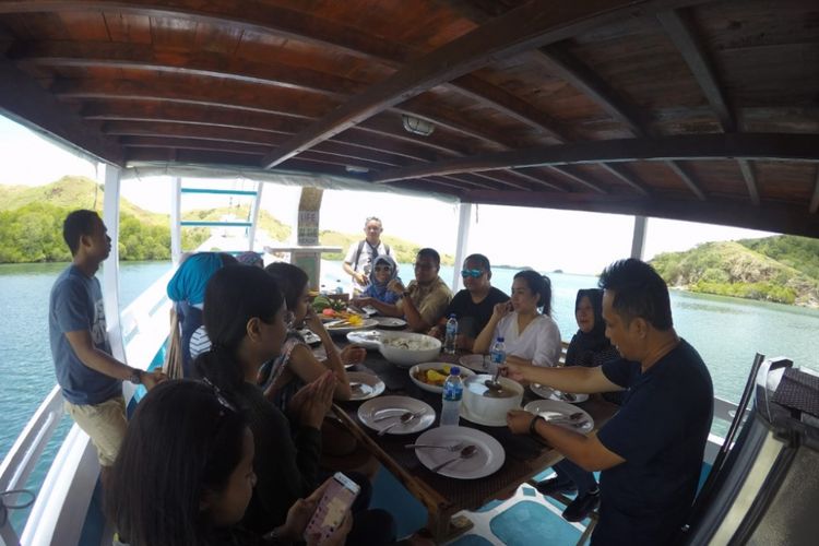 Wisatawan menikmati santab siang di atas kapal semi phinisi Wae Rebo di Pelabuhan Labuan Bajo, Nusa Tenggara Timur.