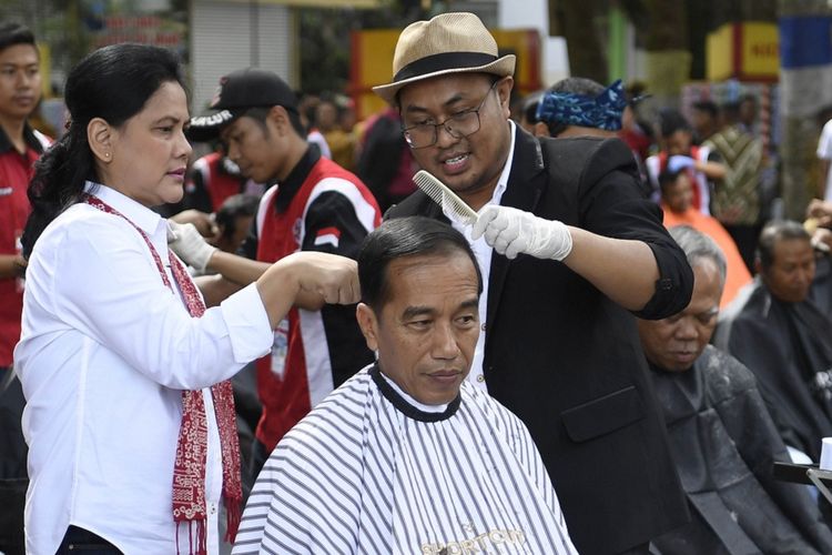Presiden Joko Widodo (tengah) didampingi Ibu Negara Iriana Joko Widodo (kedua kiri) saat mengikuti potong rambut massal di area wisata Situ Bagendit, Garut, Jawa Barat, Sabtu (19/1/2019). ANTARA FOTO/Puspa Perwitasari/foc.