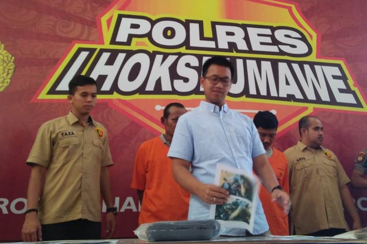 Kasat Reskrim Polres Lhokseumawe, AKP Indra T Herlambang memperlihatkan tersangka dan barang bukti kasus pembunuhan yang dilakukan ayah angkat terhadap anaknya di Mapolres Lhokseumawe, Rabu (13/3/2019)