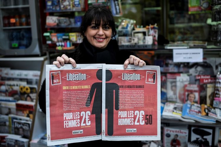Seorang perempuan Perancis memegang dua versi koran Liberation yang diterbitkan khusus untuk Hari Perempuan Sedunia, Kamis (8/3/2018).
