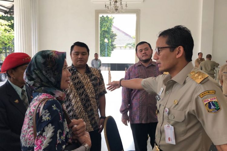 Wakil Gubernur DKI Jakarta Sandiaga Uno berbicara bersama Istiqomah, warga yang kerap datang untuk meminta pekerjaan, di Balai Kota DKI, Senin (16/4/2018). 