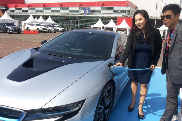 Vice President Corporate Communications BMW Group Indonesia, Jodie Otania mempraktekan cara menyalurkan listrik ke mobil listrik i8 pada hari kedua ajang International Motor Show (IIMS), di JIExpo Kemayoran, Jakarta, Jumat (20/4/2018). 