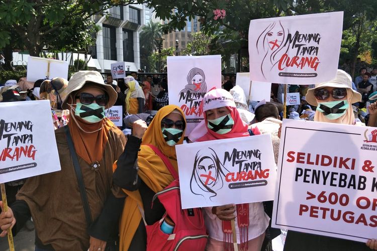 Emak-emak peserta aksi di Patung Kuda, Jakarta Pusat gunakan masker bertanda silang, Selasa (18/6/2019)