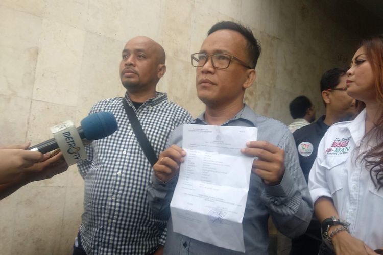 Ketua Umum Tim Jokowi Mania Immanuel Ebenezer menunjukkan laporan terhadap perempuan perekam video seorang pria yang mengancam memenggal Presiden Joko Widodo, di Mapolda Metro Jaya, Minggu (12/5/2019).