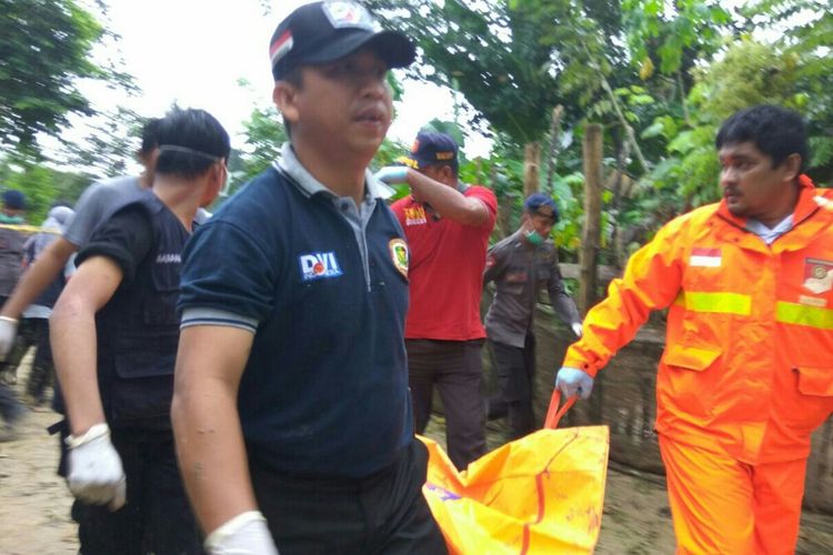 Petugas Identifikasi dari RS Bhayangkara dan Polda Sultra saat mengangkat kantong mayat perempuan yang ditemukan di sekitar Sungai Wanggu Kendari.(KOMPAS.COM/KIKI ANDI PATI) 