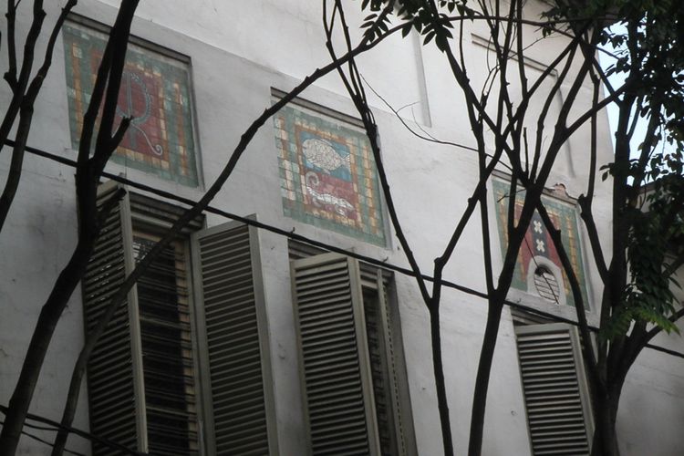 Simbol kota dengan seni patri kaca, diantaranya simbol Kota Surabaya dengan gambar ikan hiu dan buaya, terdapat di bagian dinding luar gedung bekas Escomptobank (dibangun tahun 1904) yang menghadap Jalan Pintu Besar Utara, Jaka rta .