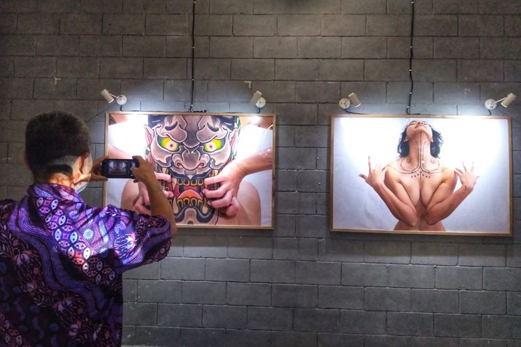 Seorang pengunjung tengah memotret foto-foto yang dipajang dalam pameran CIN(TA)TTOOKEPADAKU (Cintaku Kepadaku), Jumat (21/6/2019) malam. 