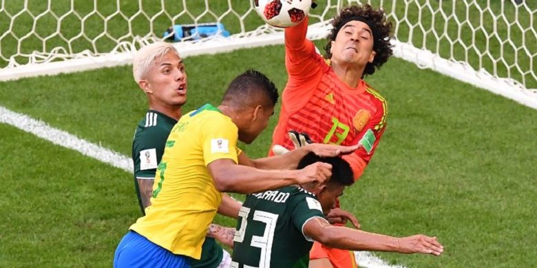 Guillermo Ochoa lebih cepat daripada Casemiro dalam menyambut bola pada pertandingan Brasil vs Meksko dalam babak 16 besar Piala Dunia 2018 di Samara Arena, 2 Juli 2018. 