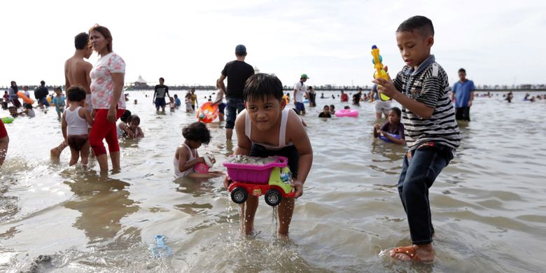 Pengunjung memanfaatkan liburan mengunjungi pantai di kawasan Taman Impian Jaya Ancol, Jakarta, Selasa (27/6/2017). Sejumlah lokasi wisata di Jakarta padat pengunjung pada libur lebaran. KOMPAS IMAGES/KRISTIANTO PURNOMO