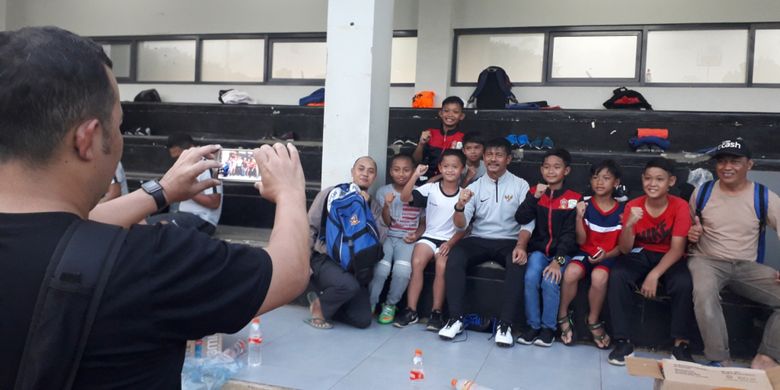 Pelatih tim nasional U-22 Indonesia, Indra Sjafri melayani permintaan foto para penggemarnya usai sesi latihan di Lapangan ABC, Kompleks GBK, Jakarta, Kamis (14/2/2019).