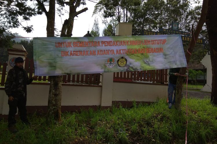 Petugas memasang banner larangan untuk mendaki Gunung Ijen. Banner dipasang di beberapa titik di Paltuding
