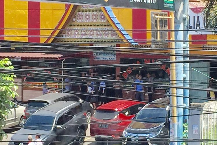 Para warga dan aparat kepolisian yang sementara makan di sebuah rumah makan di ruas jalan Martadinata, Kelurahan Dendengan Luar, Kecamatan Paal Dua, keluar dari dalam bangunan.
