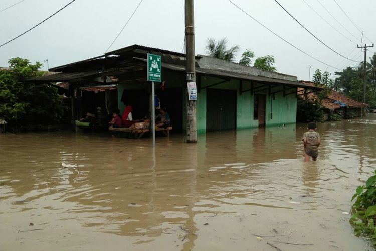 Meskipun banjir menerjang rumah mereka, Rabu (7/2/2018), warga Kampung Pengasinan, Desa Karangligar, Kecamatan Telukjambe Barat, belum mengungsi.