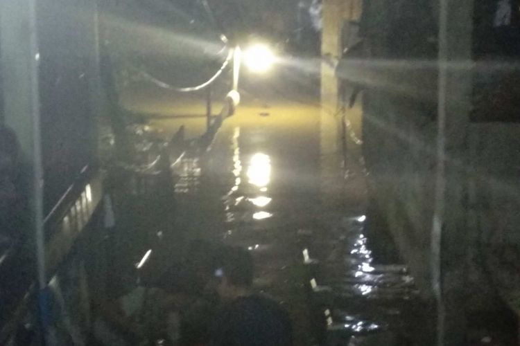 Warga Jalan Arus, Cawang mengevakuasikan diri dan harta benda dari banjir pada Senin (5/2/2018) malam.