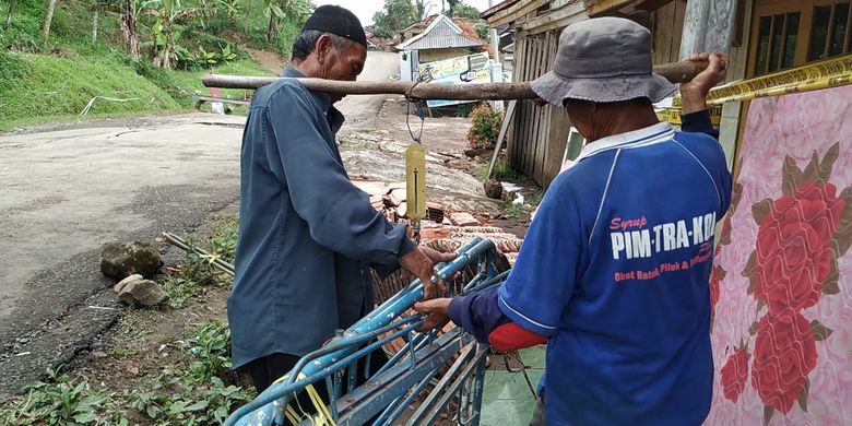 Uma (kiri) warga terdampak bencana gerakan tanah menimbang tempat tidur besi di Kampung Gunubhbatu, Desa Kertaangsana, Nyalindung, Sukabumi, Jawa Barat, Rabu (1/5/2019). 