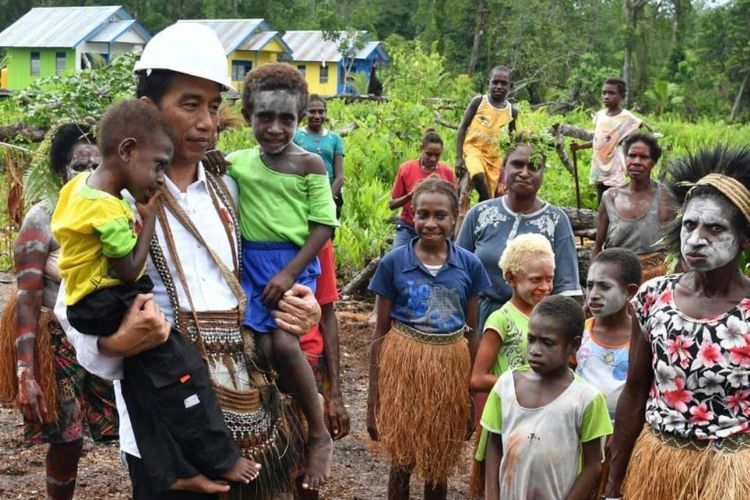 Presiden Joko Widodo menggendong dua balita di Kampung Kayeh, Kota Agats, Kabupaten Asmat, Papua, Kamis (12/4/2018). Balita berkaus kuning juga bernama Jokowi.