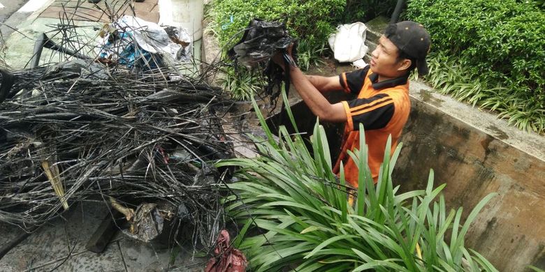 Pasukan oranye atau petugas Penanganan Prasarana dan Sarana Umum (PPSU) Kelurahan Kuningan Barat menemukan kulit kabel di saluran air sebabkan Jalan Gatot Subroto tergenang pada Kamis (2/3/2017) petang. 