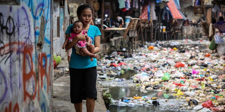 Warga berjalan di dekat kali yang dipenuhi sampah di Jln. Jati Bunder, Kel. Kebon Melati, Kec. Tanah Abang, Jakarta Pusat , Selasa (5/9/2017). Pemprov DKI Jakarta bersama dengan PemerintaPemprov DKI Jakarta bersama dengan Pemerintah Pusat akan menata kawasan kumuh melalui pencanangan program 100-0-100 yang dicanangkan Kementerian Pekerjaan umum dan Perumahan Rakyat dengan target Jakarta bebas dari kawasan kumuh pada tahun 2019. 