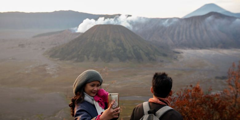Pengunjung berfoto di lokasi wisata Bukit Cinta, Pasuruan, Jawa Timur, Sabtu (4/11/2017). Bukit Cinta menjadi alternatif menyaksikan matahari terbit di kawasan wisata Gunung Bromo. KOMPAS IMAGES/KRISTIANTO PURNOMO
