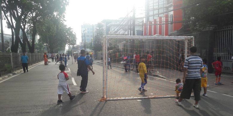 Warga memanfaatkan kegiatan car free day di Jalan Tomang Raya untuk bermain sepakbola, Minggu (15/4/2018).