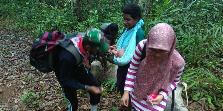 Perawat Tim Nusantara Sehat, Merixz. memberikan imunisasi di tengah hutan pedalaman Papua kepada seorang bayi berusia 2 bulan.
