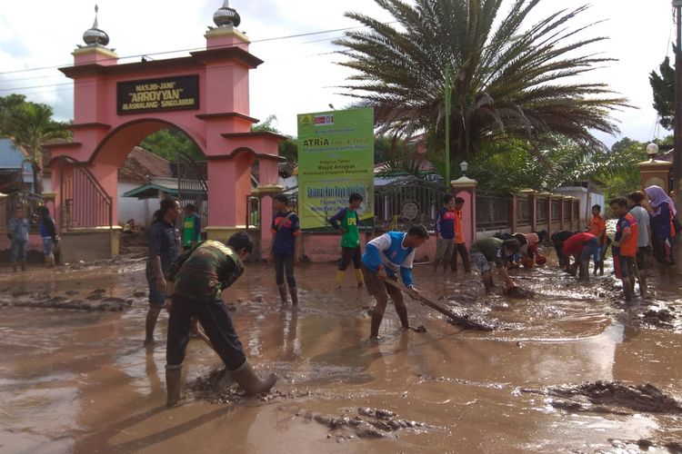 Proses pembersihan lumpur di jalan utama Desa Alasmalang yang terkena banjir bandang pada 22 Juni 2018 lalu
