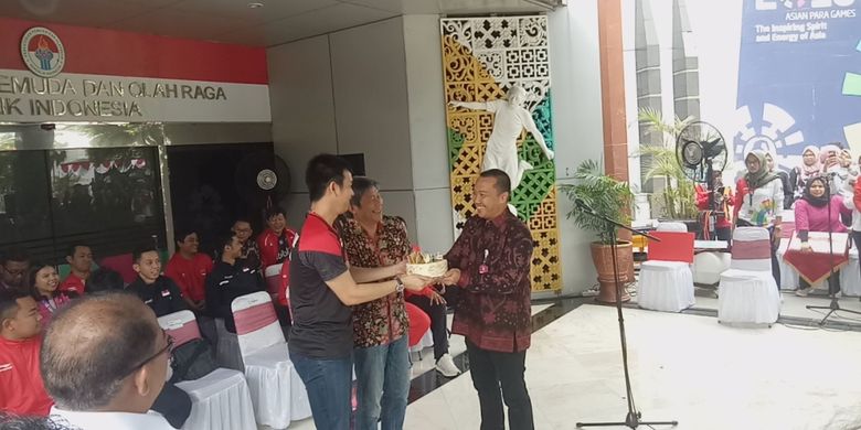 Menpora Imam Nahrawi (kanan) saat memberikan kue ulang tahun kepada pebulu tangkis Indonesia, Hendra Setiawan dalam acara pemberian bonus untuk para pebulu tangkis yang sudah menorehkan medali di Kejuaraan Dunia 2019, baik badminton maupun para badminton, di Kantor Kemenpora, Jakarta, Rabu (28/8/2019).
