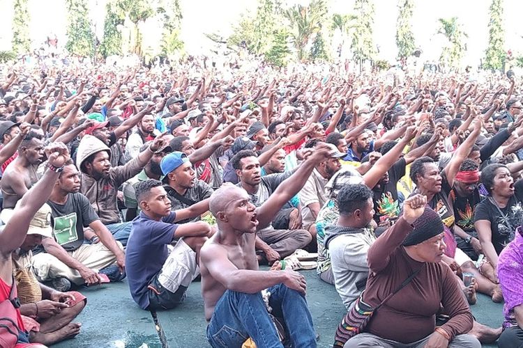 Ribuan massa duduk bersila di Lapangan Apel Kantor Gubernur Papua, Senin (19/08/2019). Mereka yang ditemui Gubernur Papua Lukas Enembe, melakukan aksi protes terhadap penangkapan 43 mahasoswa Papua di Surabaya, Jawa Timur pada 16 Agustus 2019