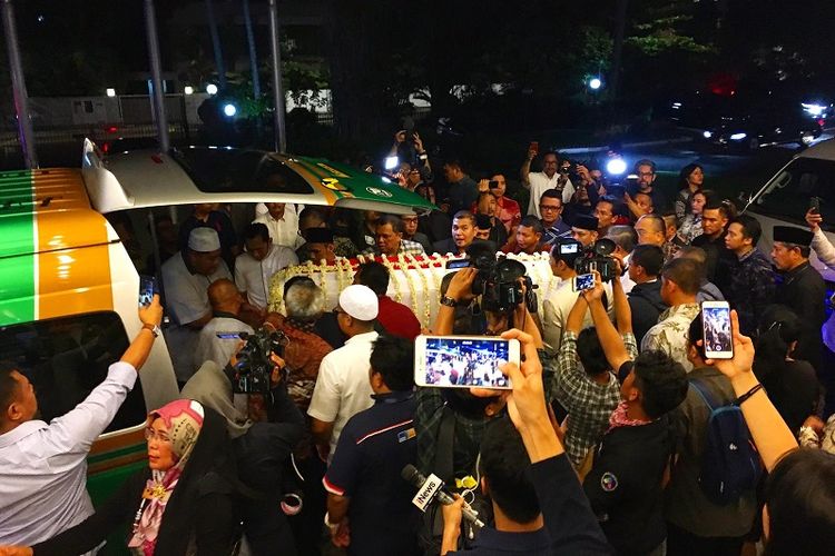 Jenazah mantan Ibu Negara Ani Yudhoyono diangkat menuju mobil dibawa ke Pangkalan Militer Paya Lebar untuk diterbangkan ke Jakarta, Sabtu malam (1/6/2019). (Kompas.com/Ericssen)