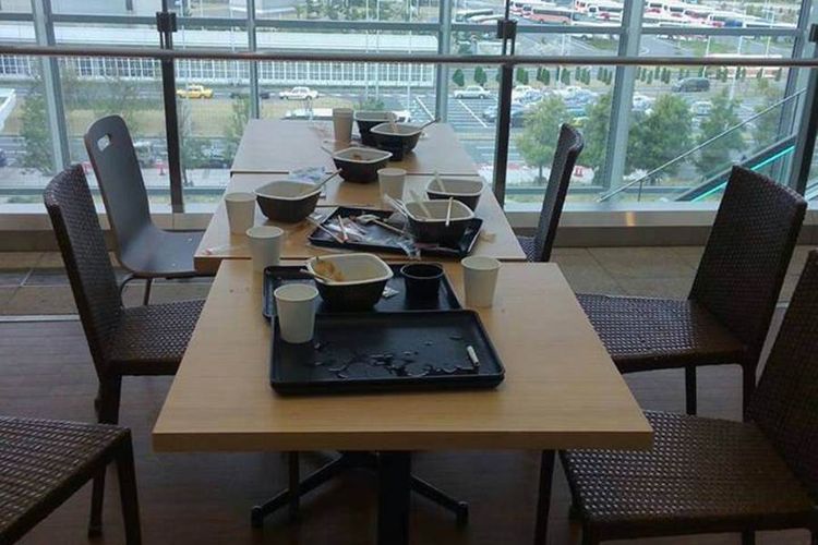 Meja yang berserakan di salah satu tempat makan di Bandara Haneda, Tokyo, Jepang setelah rombongan turis Indonesia selesai makan. Beberapa tempat makan cepat saji di Jepang memang mengharuskan pelanggannya untuk membereskan sendiri meja yang telah ditempati.