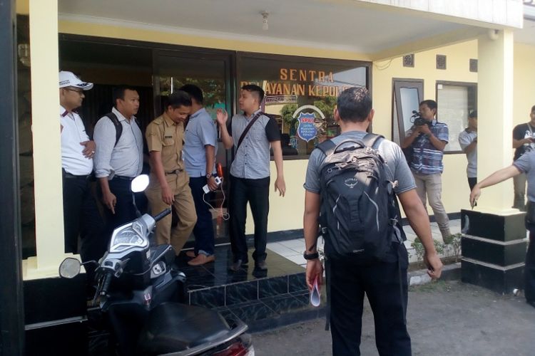 Seorang PNS BKD Garut keluar dari Polsek Tarogong Kaler dikawal sejumlah anggota tim Saber Pungli, Selasa (8/5/2018).