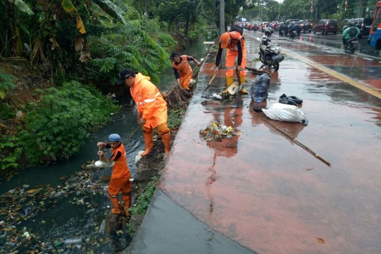 Pasukan Oranye membersihkan saluran air yang sempat menjadi perbincangan netizen di Facebook terkait kotor dan banyak sampah pada Senin (25/6/2018).  