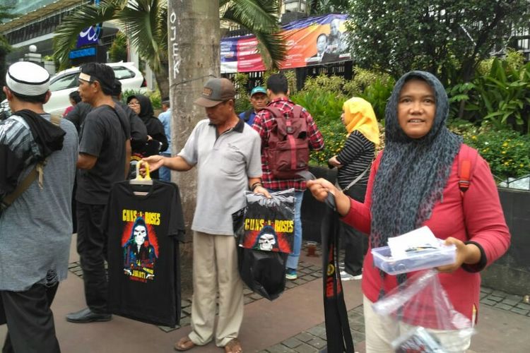 Para penjual t-shirt non-official Guns N Roses menjajakan dagangan mereka di sekitar area konser di Stadion Utama Gelora Bung Karno, Senayan, Jakarta Pusat, Kamis (8/11/2018) siang.