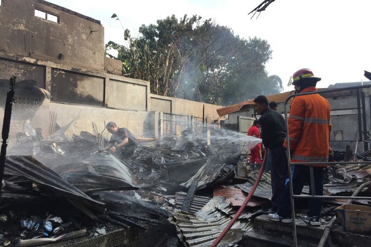 Api dipadamkan saat kebakaran di Jalan Dewi Sartika, Jumat (10/8/2018).