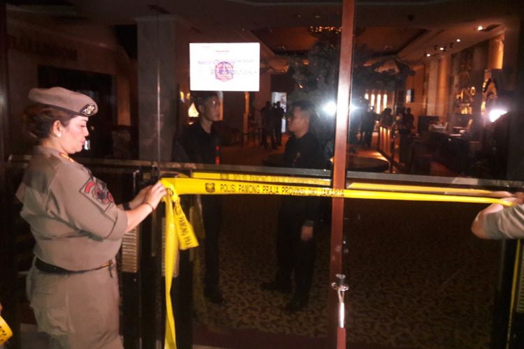 Petugas Satpol PP memasang garis pembatas di pintu masuk ballroom Sense di Mal Mangga Dua Square, Jakarta Utara, Kamis (19/4/2018).