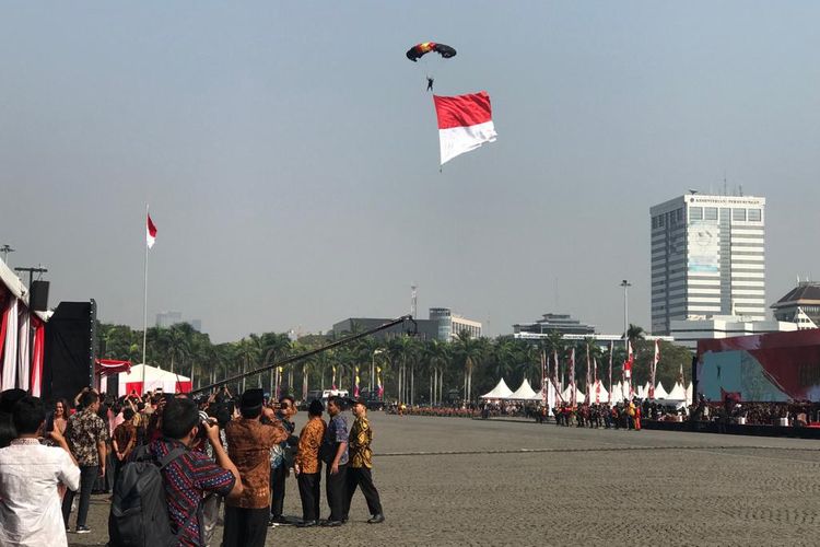 Penerjun pembawa bendera Merah Putih saat akan mendarat dalam acara peringatan HUT ke-73 Bhayangkara di Lapangan Silang Monas, Jakarta Pusat, Rabu (10/7/2019) pagi.