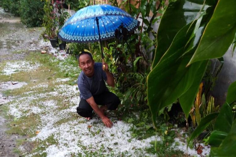 Suprihono (42), warga Kampung Paya Tungel, Kecamatan Jagong Jeget, Kabupaten Aceh Tengah saat menunjukan hujan es yang terjadi pada Minggu (7/7/2019) siang di halaman rumahnya.