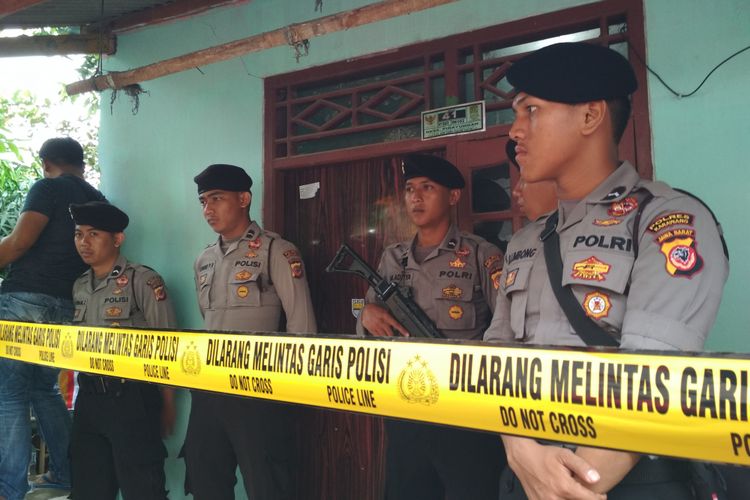 Polisi bersenjata lengkap berjaga di TKP mutilasi di sebuah kontrakan di Karawang, Rabu (13/12/2017).