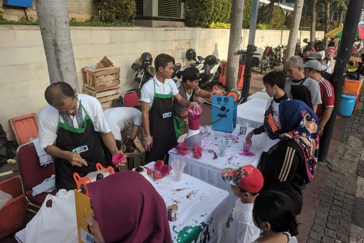 Relawan Pengusaha Muda Nasional membagikan jusnbuah naga gratis dalam rangka mengkampanyekan buah lokal di lokasi CFD Bundaran HI, Jakarta Pusat pada Minggu (10/2/2019)