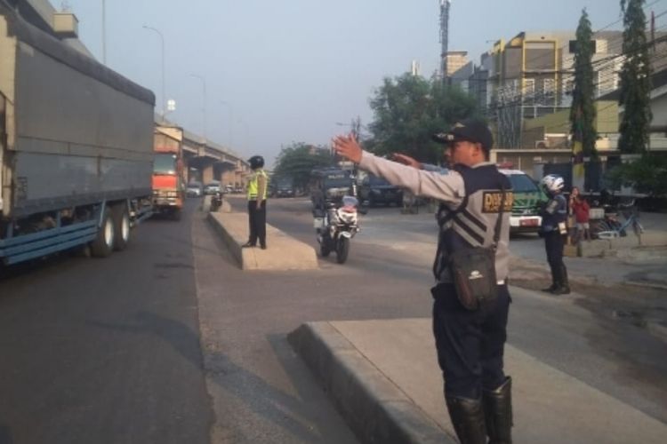 Petugas Dinas Perhubungan DKI Jakarta tampak mengatur arus lalu lintas dari trotoar di median Jalan Raya Kalimalang, Duren Sawit, Jakarta Timur, Senin (16/9/2019).