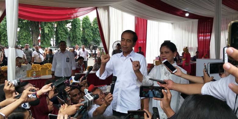 Jokowi didampingi istri, Iriana Jokowi, mencoblos di Tempat Pemungutan Suara (TPS) 008 yang terletak di pelataran gedung Lembaga Administrasi Negara, Kelurahan Gambir, Kecamatan Gambir, Jakarta Pusat.