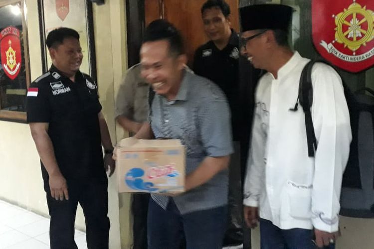 Ketua DPC Partai Gerindra Lamongan Tsalis Fahmi (kanan) dan Okta Rosadinata (bawa kardus), saat menerima pengembalian uang tunai Rp1,075 miliar di Mapolres Lamongan, Rabu (17/4/2019).