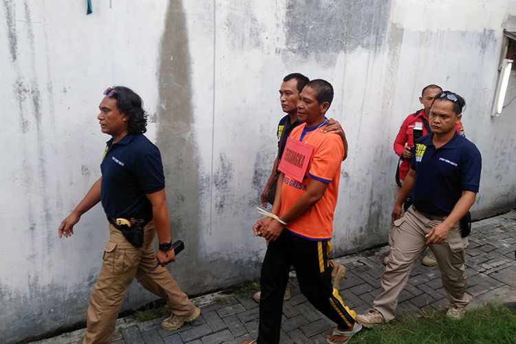 Tersangka Muhammad Choirul alias Maman (tengah), saat diminta petugas kepolisian melakukan reka ulang pembunuhan.