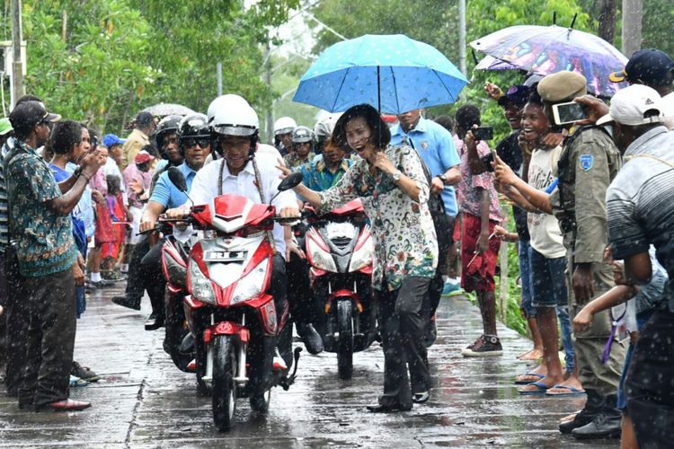 Presiden Joko Widodo bersepeda motor membonceng Ibu Negara Iriana saat mengunjungi Kota Agats, Kabupaten Asmat, Papua, Kamis (12/4/2018). 