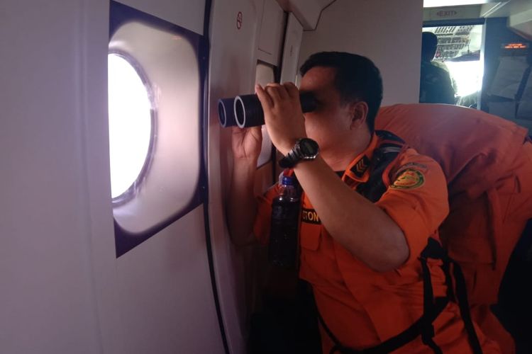 Seorang personel SAR tengah memantau perairan dari pesawat udara patroli maritim U-6212 milik TNI AL, Senin (13/5/2019) 