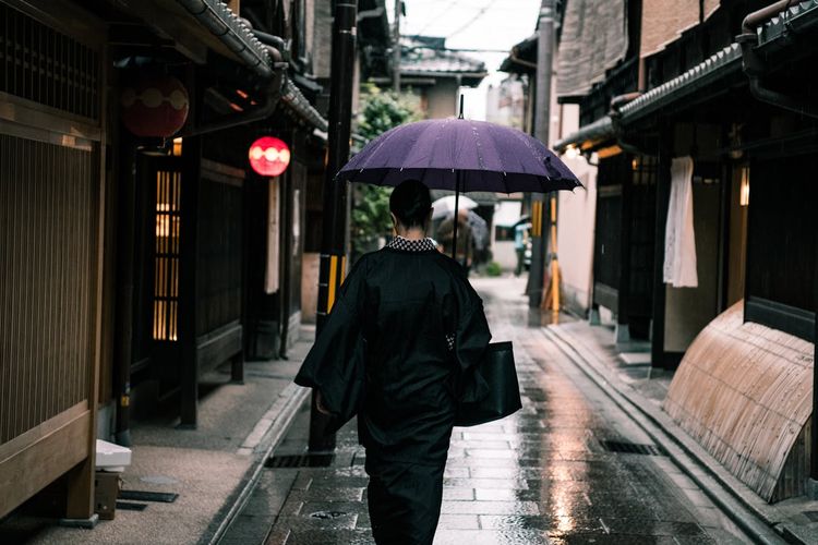 Ilustrasi seorang perempuan memakai payung saat hujan di Kyoto, Jepang. 