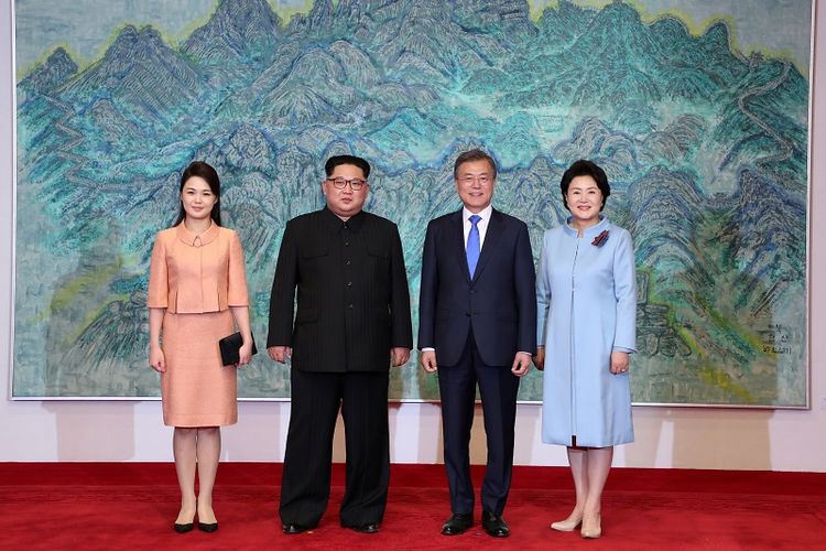 Pemimpin Korea Utara Kim Jong Un dan istrinya Ri Sol Ju berfoto bersama Presiden Korea Selatan Moon Jae-in dan istrinya Kim Jung-sook sesaat sebelum jamuan makan malam di Panmunjom, Jumat (27/4/2018). 