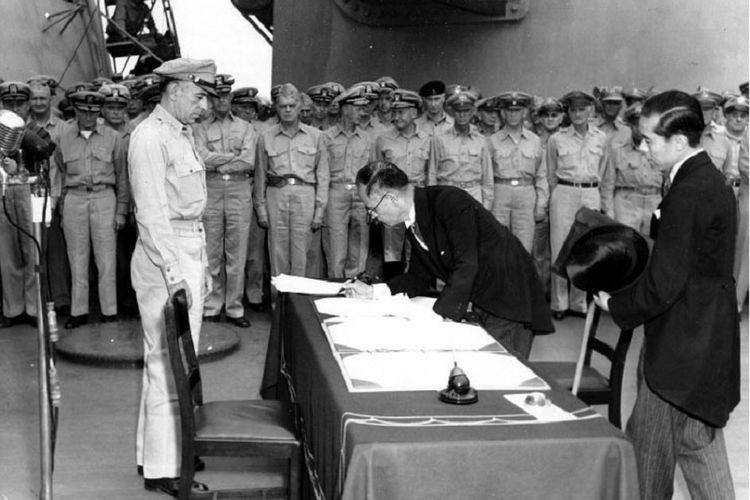 Menteri Luar Negeri Jepang Mamoru Shigemitsu menandatangani dokumen yang menyatakan penyerahan diri Jepang di geladak kapal perang USS Missouri disaksikan Jenderal Richard K Sutherland pada 2 September 1945.